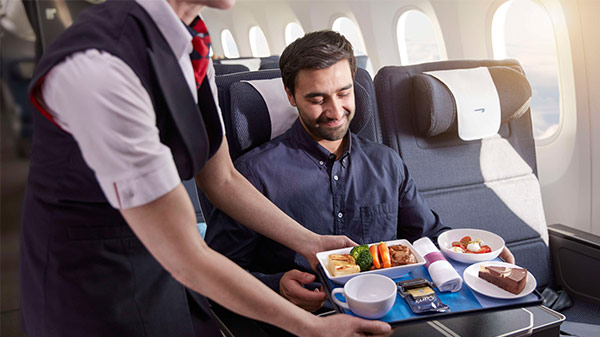A man relaxing in a World Traveller Plus premium economy seat.