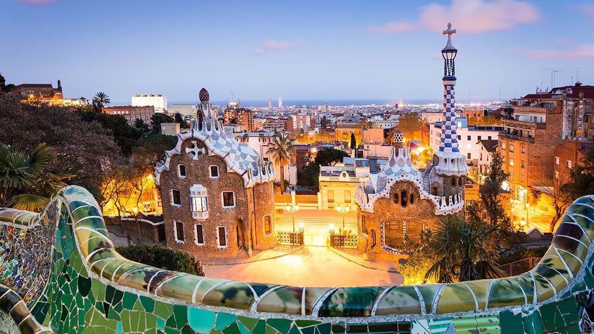 Parc Guell at sunset, view of the city with seaside in background. Barcelona, Spain.